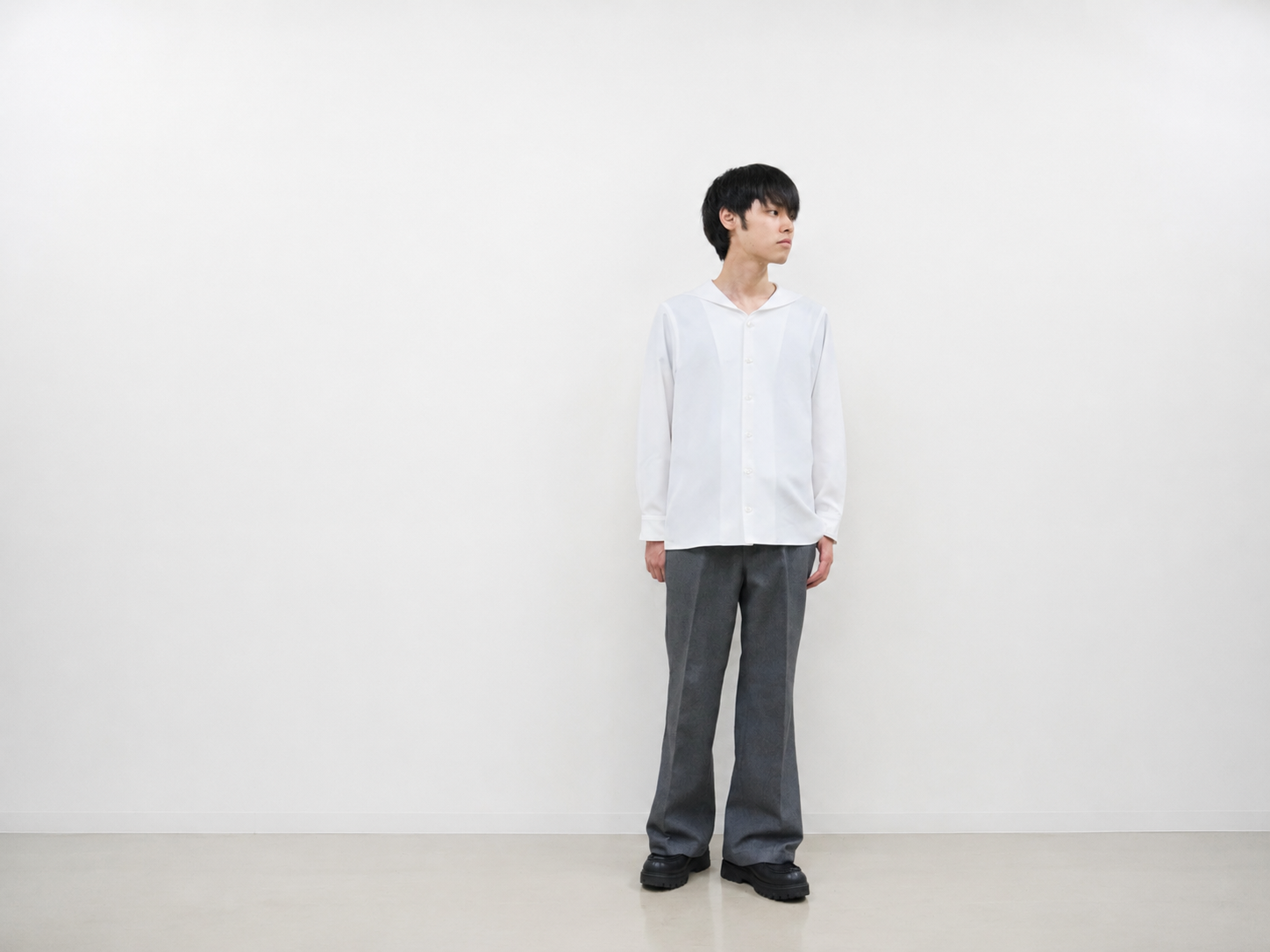 白のセーラーカラーシャツとグレーのトラウザーを着用した男性の全身コーディネート