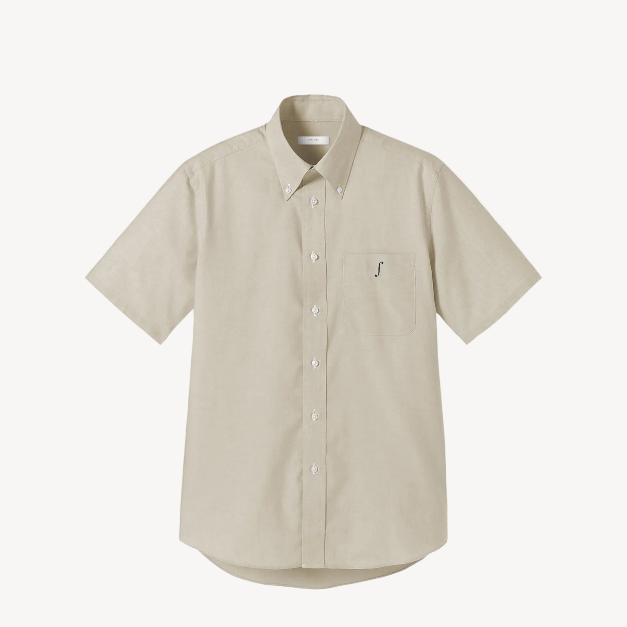 Collis Felixのベージュの半袖ボタンダウンシャツを正面から撮影した商品画像。左胸ポケットにネイビーのブランドロゴが入っている。