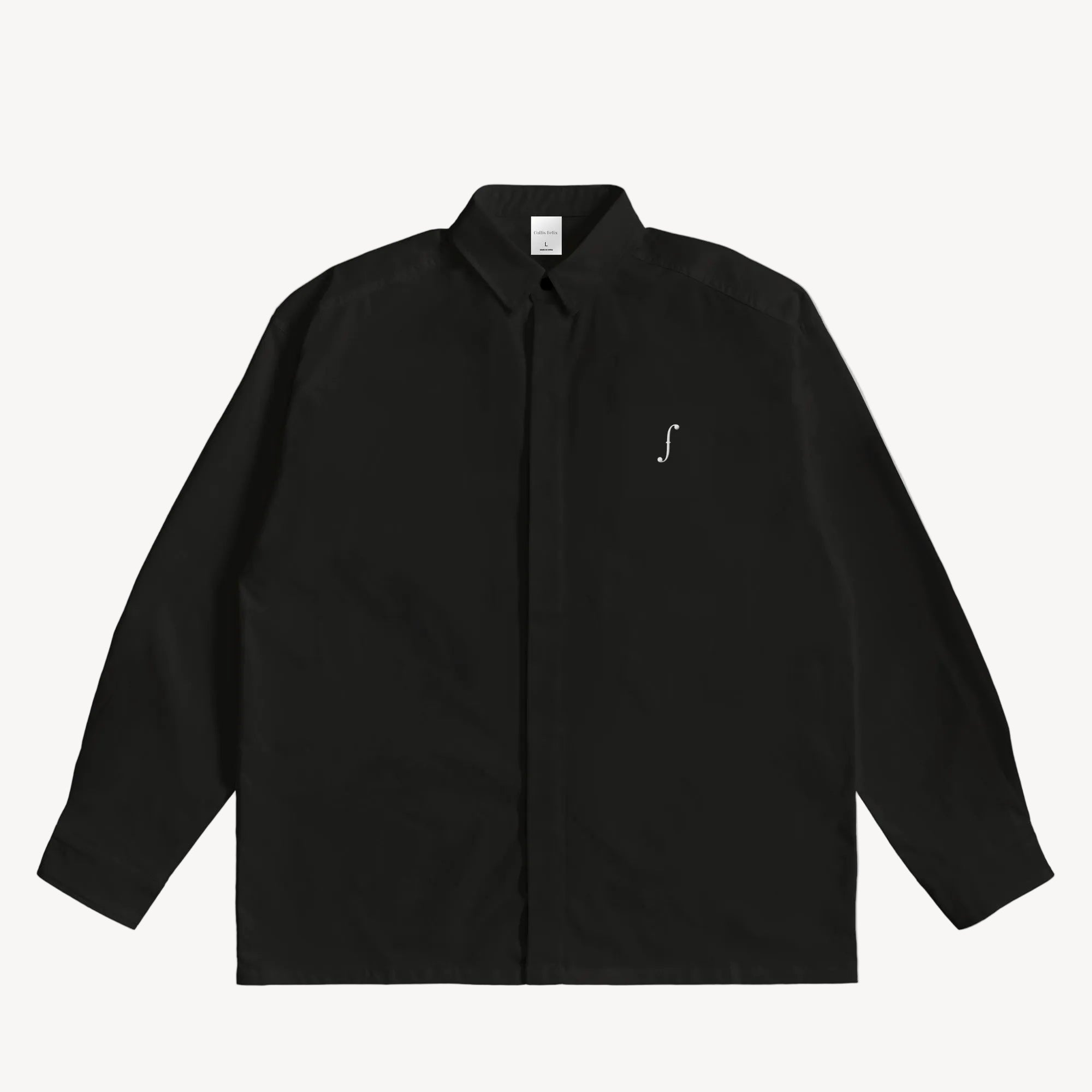 Collis Felixのブラックのロングスリーブシャツを正面から撮影した商品画像。左胸にホワイトのブランドロゴが入っている。