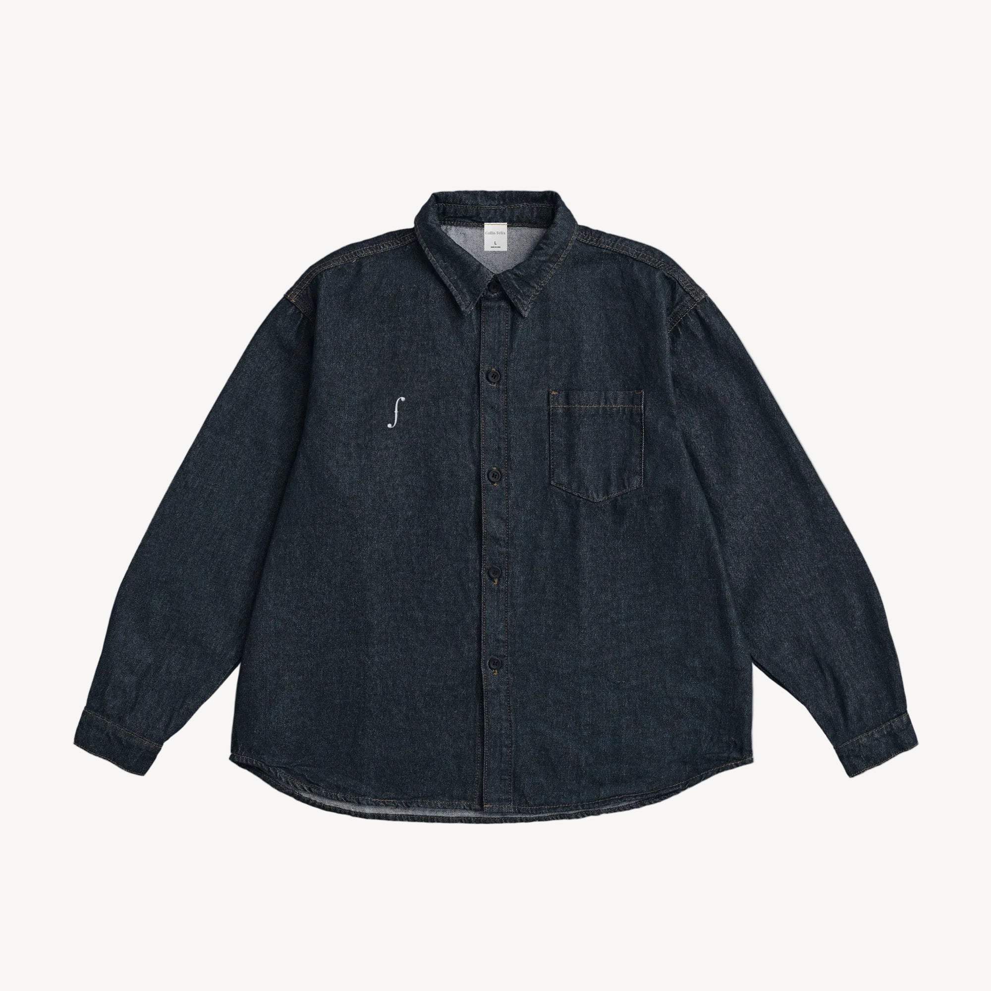 Collis Felixのインディゴのデニムシャツを正面から撮影した商品画像。胸元にブランドロゴとポケットがあり、ステッチがアクセントになっている。