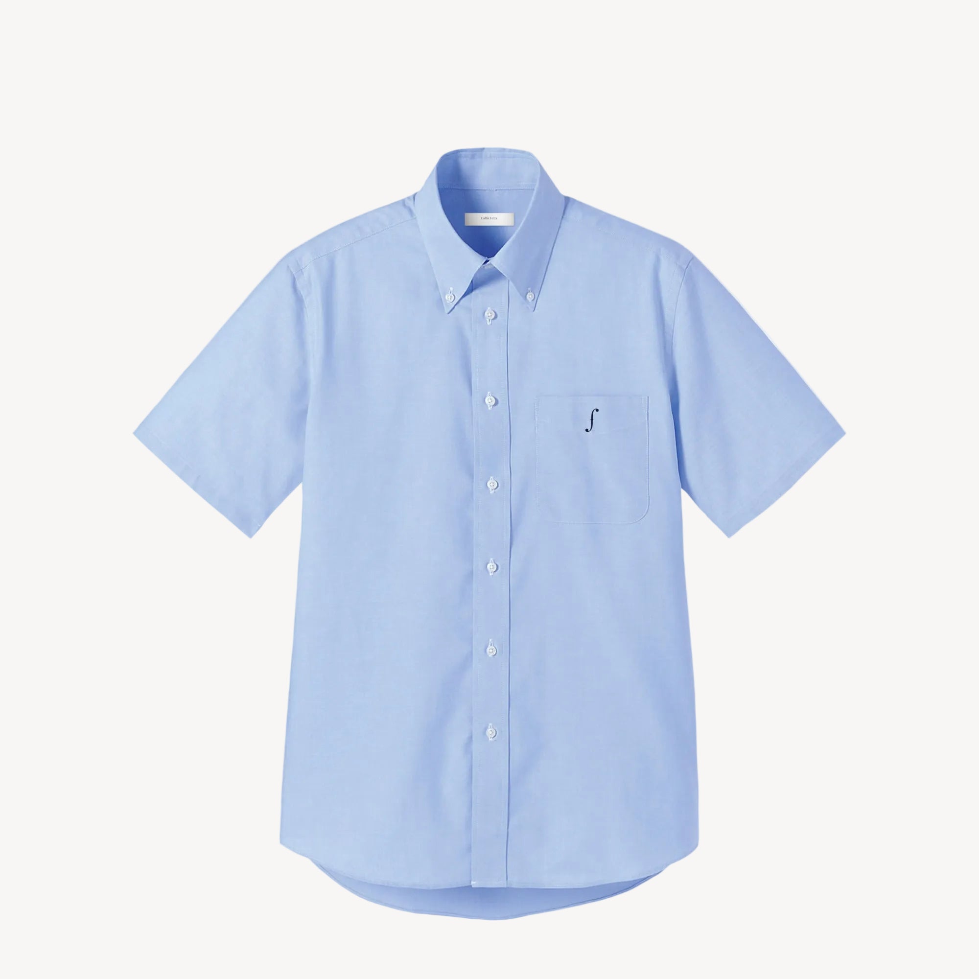 Collis Felixのライトブルーの半袖ボタンダウンシャツを正面から撮影した商品画像。左胸ポケットにネイビーのブランドロゴが入っている。