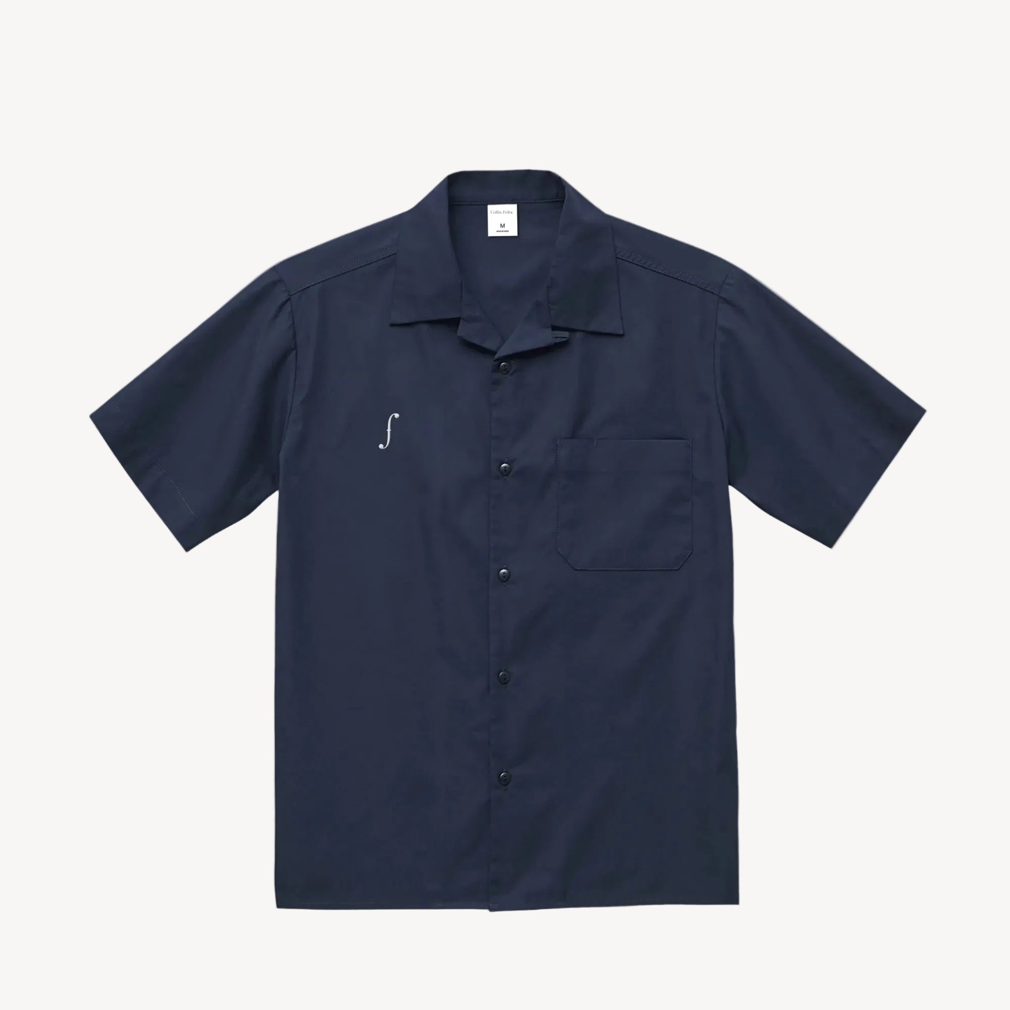 Collis Felixのネイビーのオープンカラーシャツを正面から撮影した商品画像。胸元にブランドロゴとポケットがあり、フロントにボタンが並んでいる。